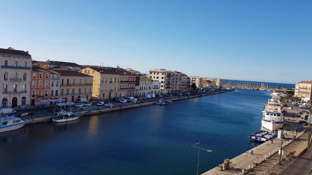 - une vue sur une rivière avec des bateaux dans une ville dans l'établissement Appartement chaleureux - 2 chambres - Canal Royal, à Sète