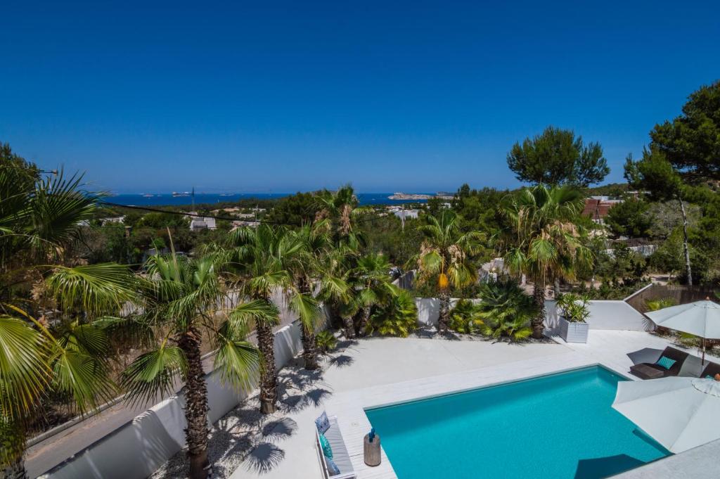 an aerial view of a resort with a swimming pool and palm trees at Can Love in Cala Comte