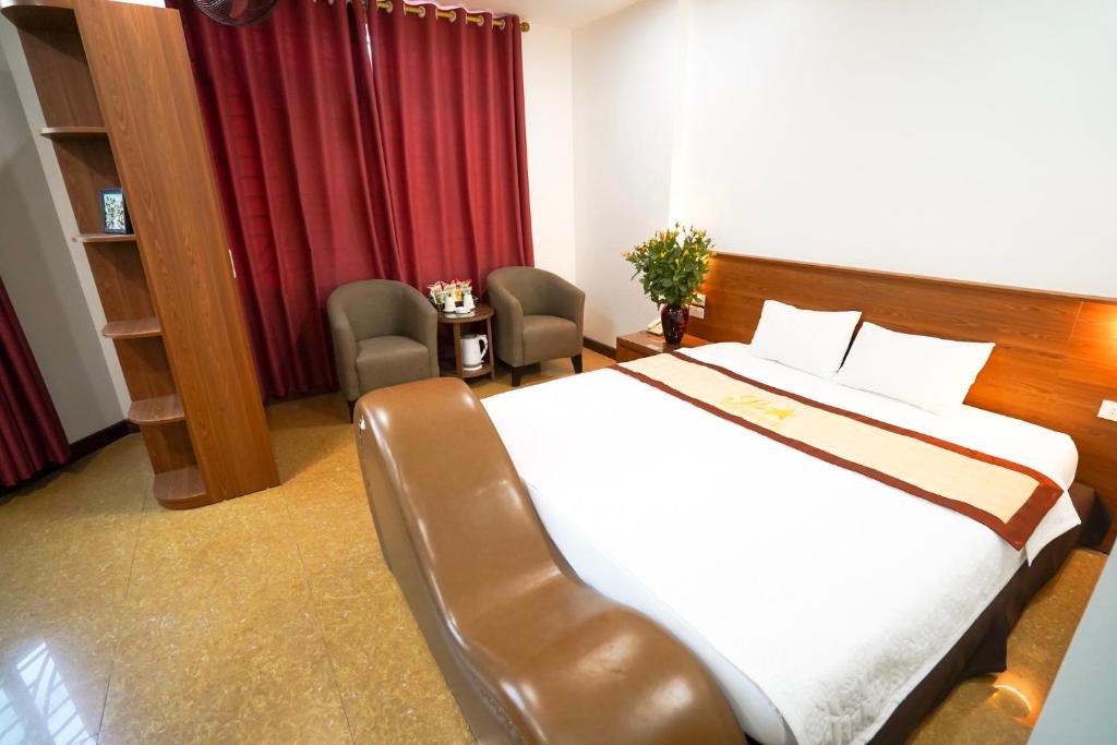 a hotel room with a bed and two chairs at Hanoi Star Hotel in Hanoi
