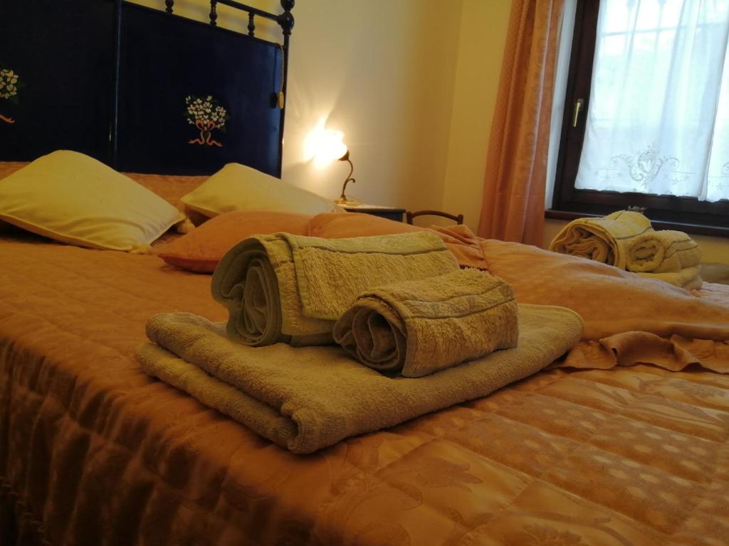 Una cama con toallas encima. en Le Viole Bianche, en Albiano dʼIvrea