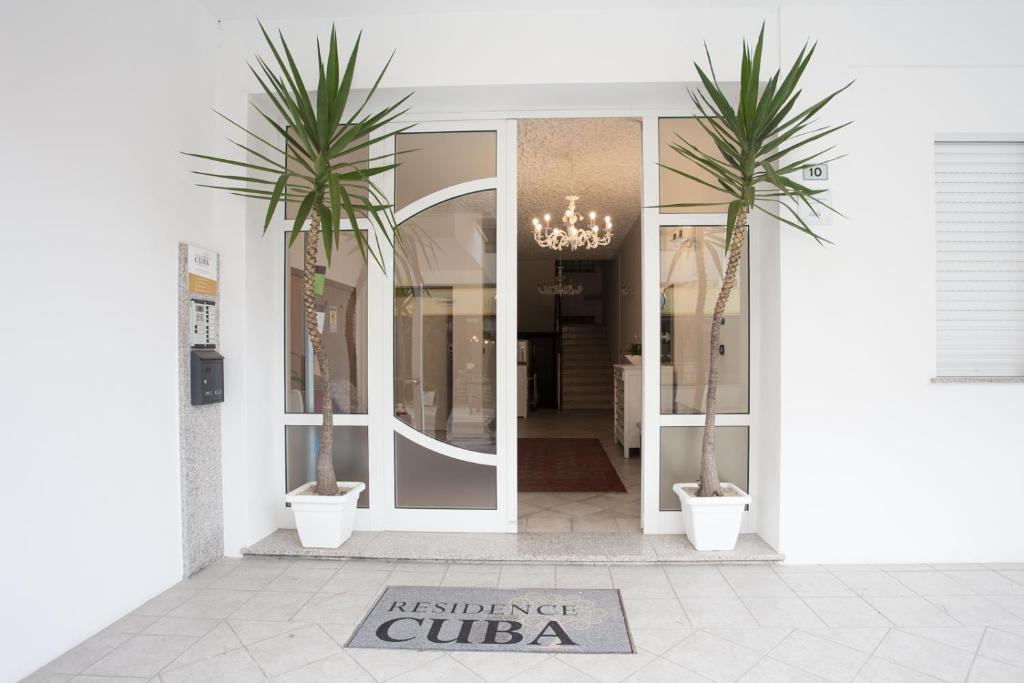 a store with two palm trees in front of a door at Residence Cuba in Riccione