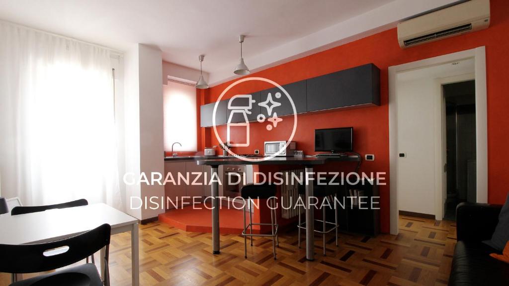 a room with a red wall with a table and chairs at Italianway-Lodi 78 in Milan