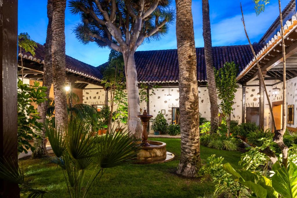 a courtyard with palm trees and a building at Parador de La Gomera in San Sebastián de la Gomera