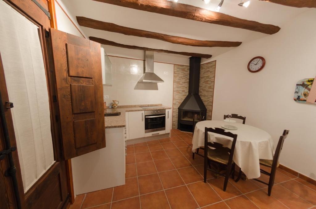 cocina con mesa y cocina con fogones en Casa Rural El Solanar, en Castelserás