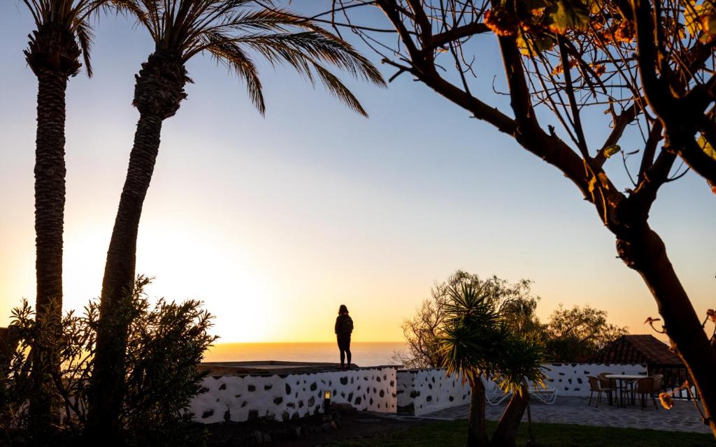 a person standing on a wall watching the sunset at Parador de La Gomera in San Sebastián de la Gomera