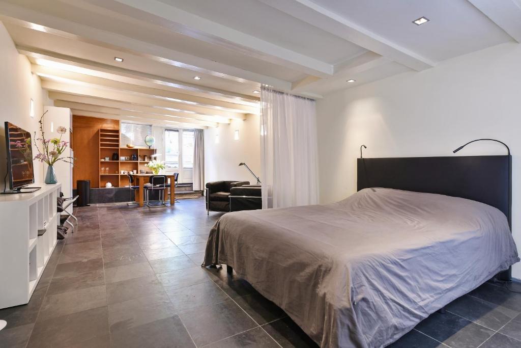 ein Schlafzimmer mit einem Bett und ein Wohnzimmer in der Unterkunft Luxueuze Studio Herengracht in Amsterdam