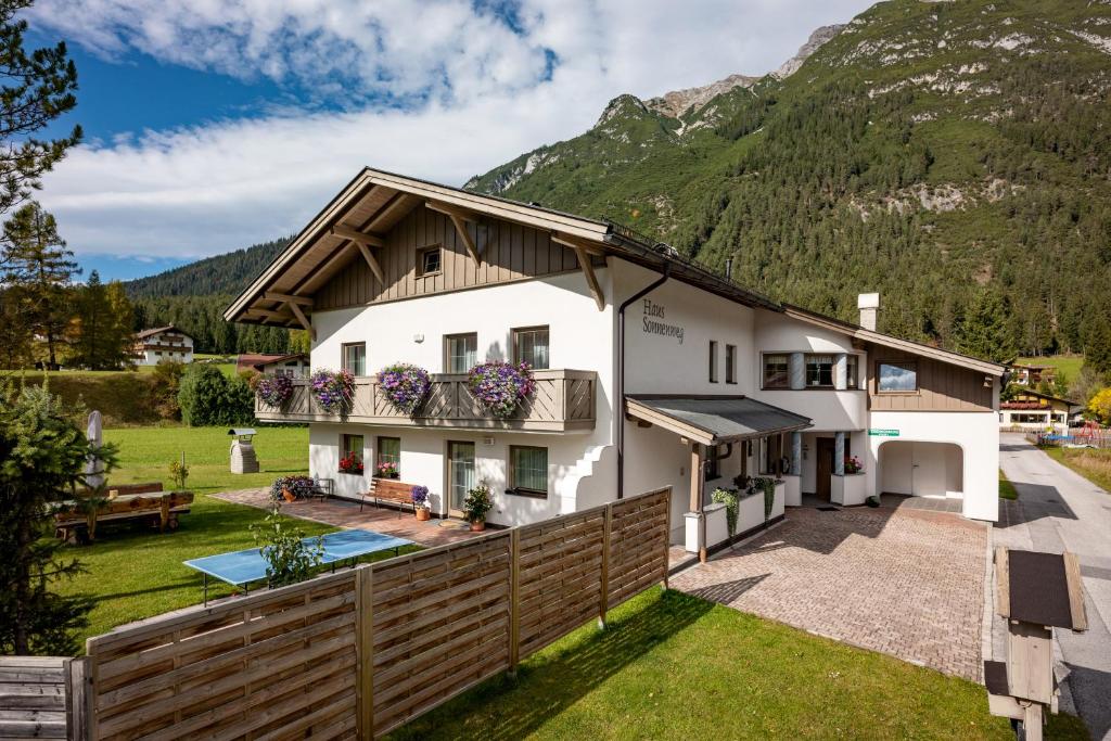 una casa en las montañas con una valla en Haus Sonnenweg en Leutasch