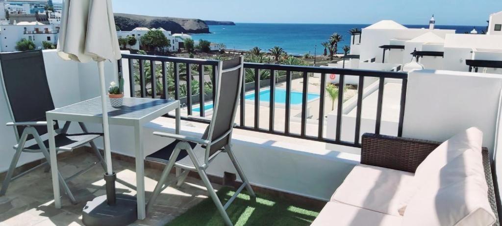 einen Balkon mit einem Tisch und Meerblick in der Unterkunft Casa Mykonos 1° linea de mar en Playa Blanca in Playa Blanca