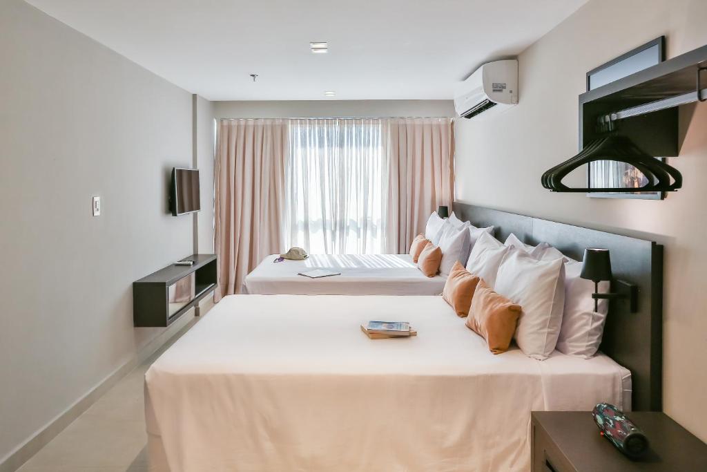 Cama ou camas em um quarto em Quality Suítes João Pessoa