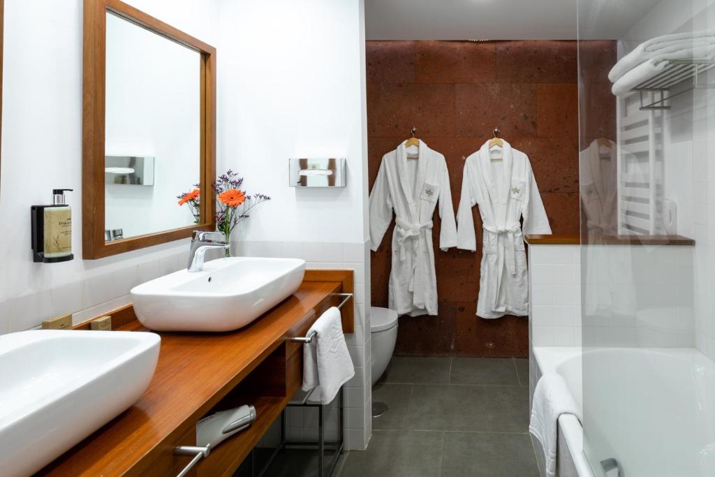 a white bathroom with two sinks and a mirror at Parador de La Gomera in San Sebastián de la Gomera