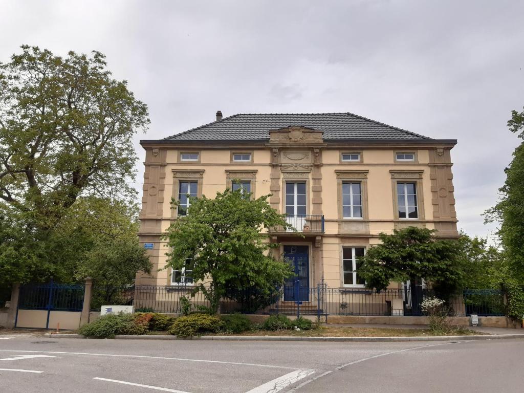 een geel gebouw met een zwart dak op een straat bij loft studio avec charme et authenticité in Altkirch