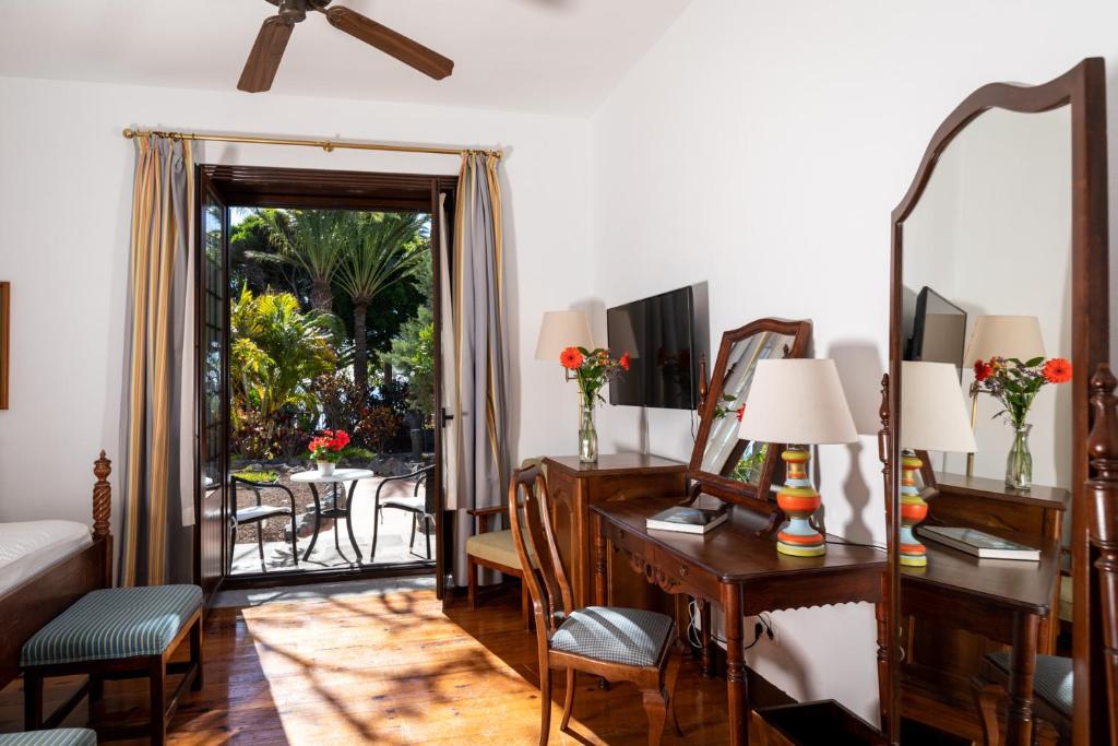 a living room with a desk and a mirror at Parador de La Gomera in San Sebastián de la Gomera