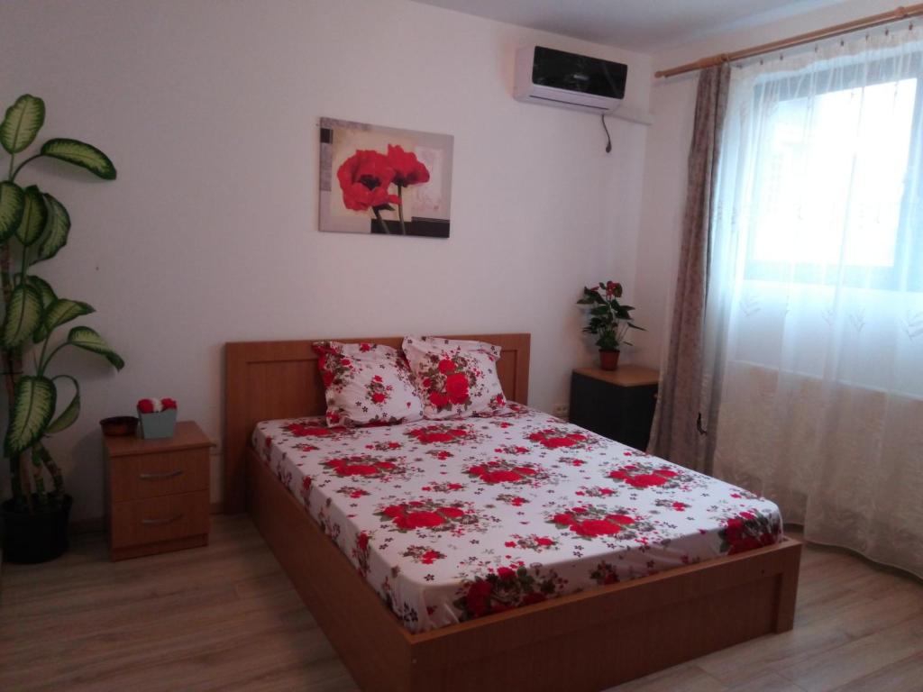 Un dormitorio con una cama con flores rojas. en Plaza Mall, en Bucarest