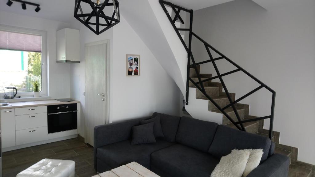 salon z kanapą i schodami w obiekcie Domki apartamentowe BALIA w mieście Mieroszyno
