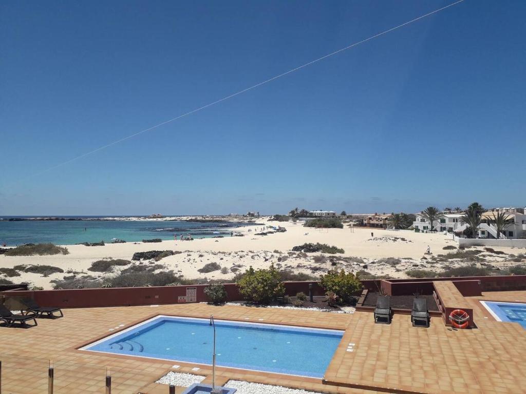 a resort with a swimming pool and a beach at Marfolín 10 in El Cotillo