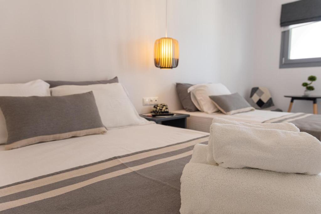a white bedroom with two beds and a couch at Fragoulis Village in Parasporos