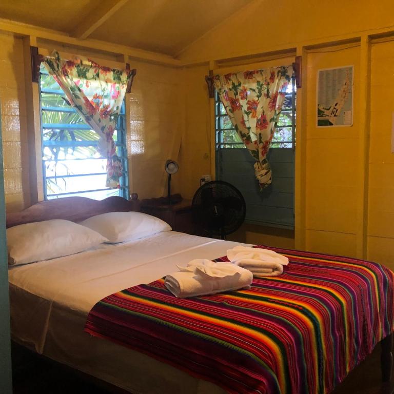 a bedroom with a bed with two towels on it at Colinda Cabanas in Caye Caulker