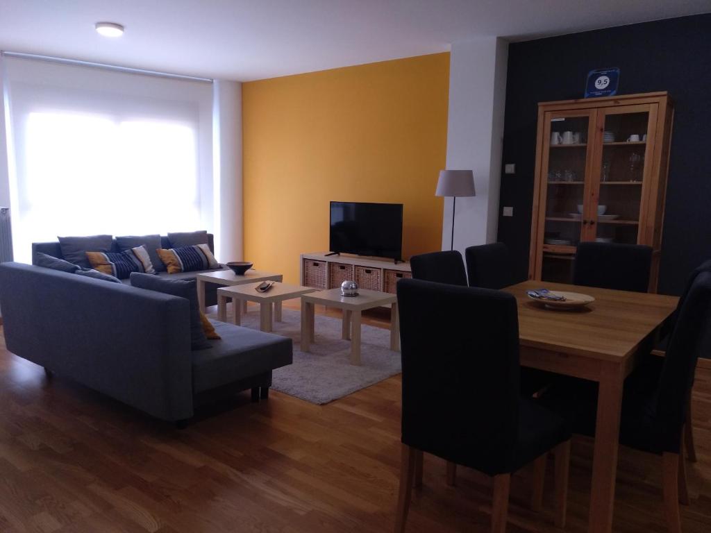 a living room with a couch and a table and a television at Apartamento Turistico Cigüeña de Arguedas in Arguedas