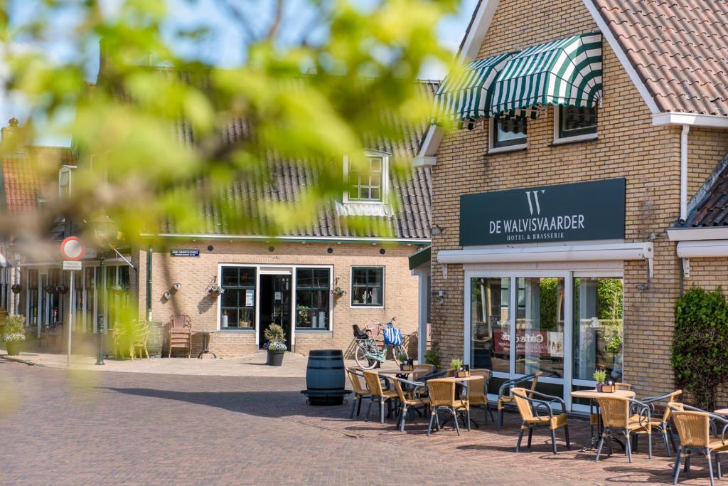 un restaurant avec des tables et des chaises en face d'un bâtiment dans l'établissement Hotel-Brasserie De Walvisvaarder, à Hollum