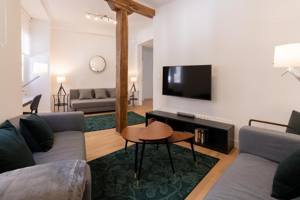 a living room with a couch and a tv at Bilbao High Apartment in Bilbao