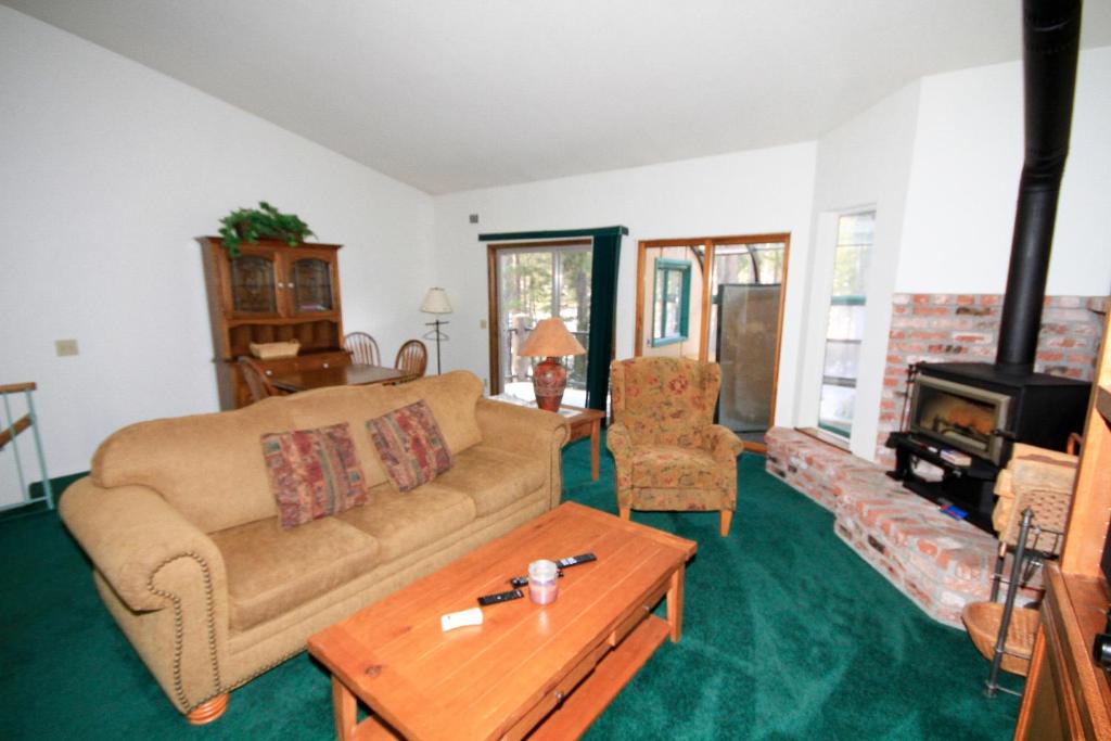 a living room with a couch and a wood stove at Forest Creek #3, Pet accepted in Mammoth Lakes
