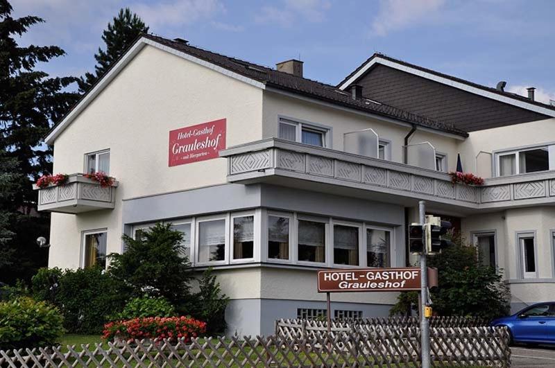 um grande edifício branco com uma placa em frente em Hotel Grauleshof em Aalen