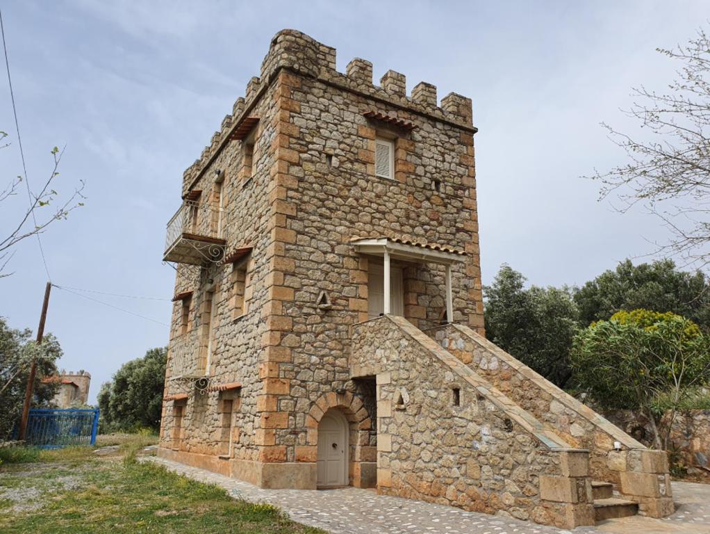 um grande edifício de pedra com uma porta lateral em Stoupa Mani Tower em Stoupa