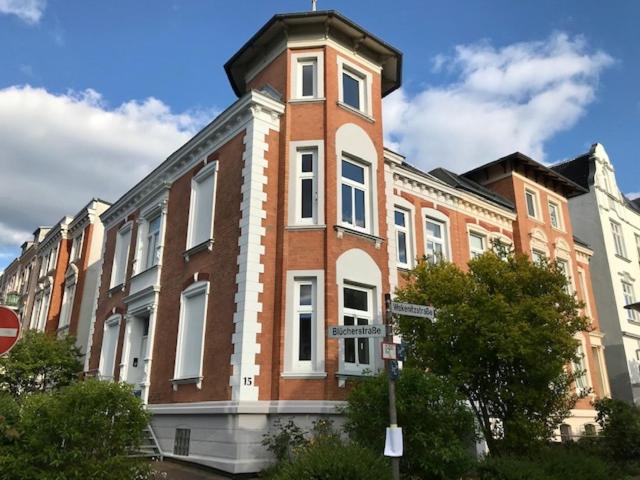 um grande edifício de tijolos com uma torre de relógio sobre ele em Villa Wakenitz em Lübeck