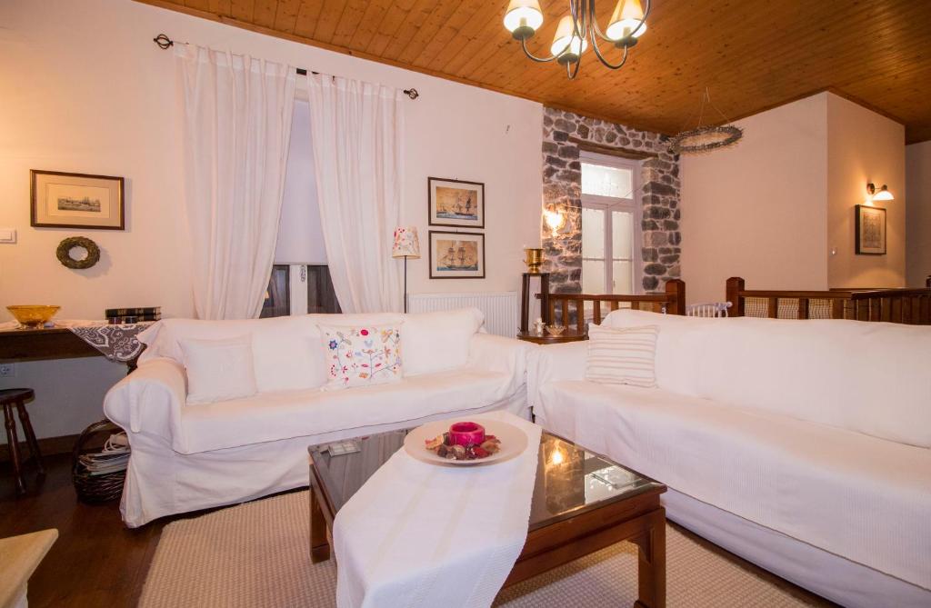 a living room with two white couches and a table at "En Hatipi" in Sparti