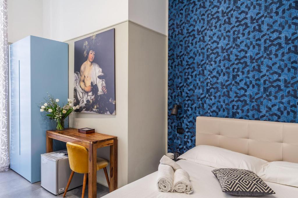 een slaapkamer met een bed en een blauwe muur bij Donna Lena Relais Napoli in Napels