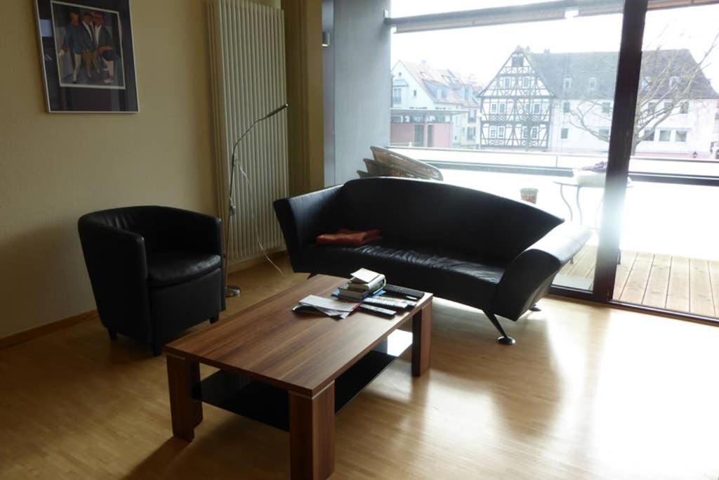 a living room with a black couch and a coffee table at Im Herzen von Aschaffenburg in Aschaffenburg