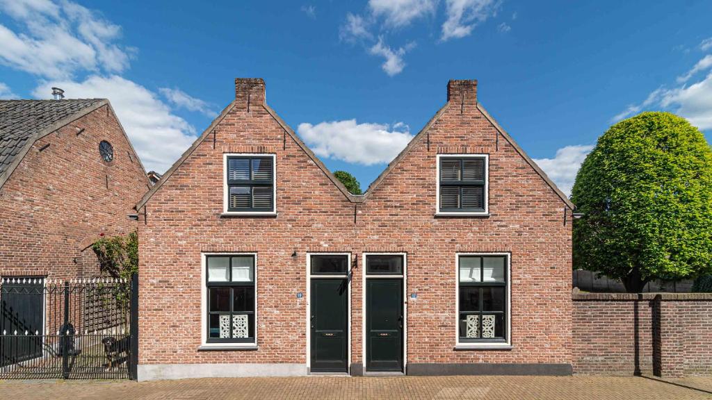 a brick house with two windows and a door at B&B Zilverstad Huisje Havenzicht in Schoonhoven