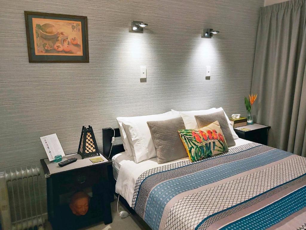 Un dormitorio con una cama con almohadas. en Rotorua City Homestay, en Rotorua
