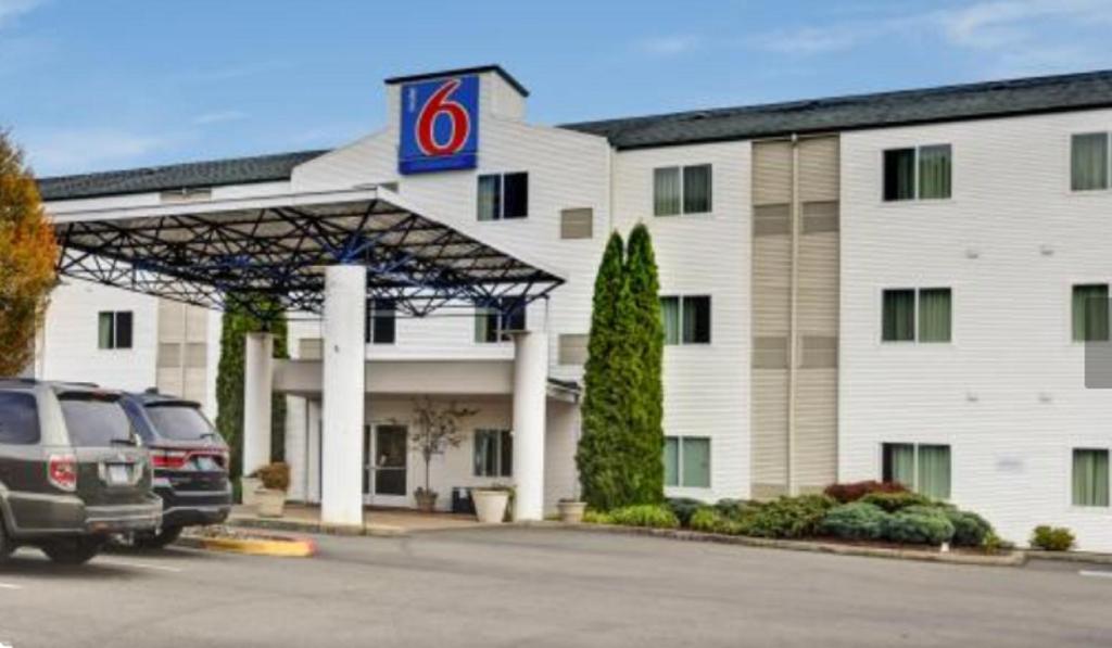 a hotel with cars parked in front of a building at Motel 6-Roseburg, OR in Roseburg