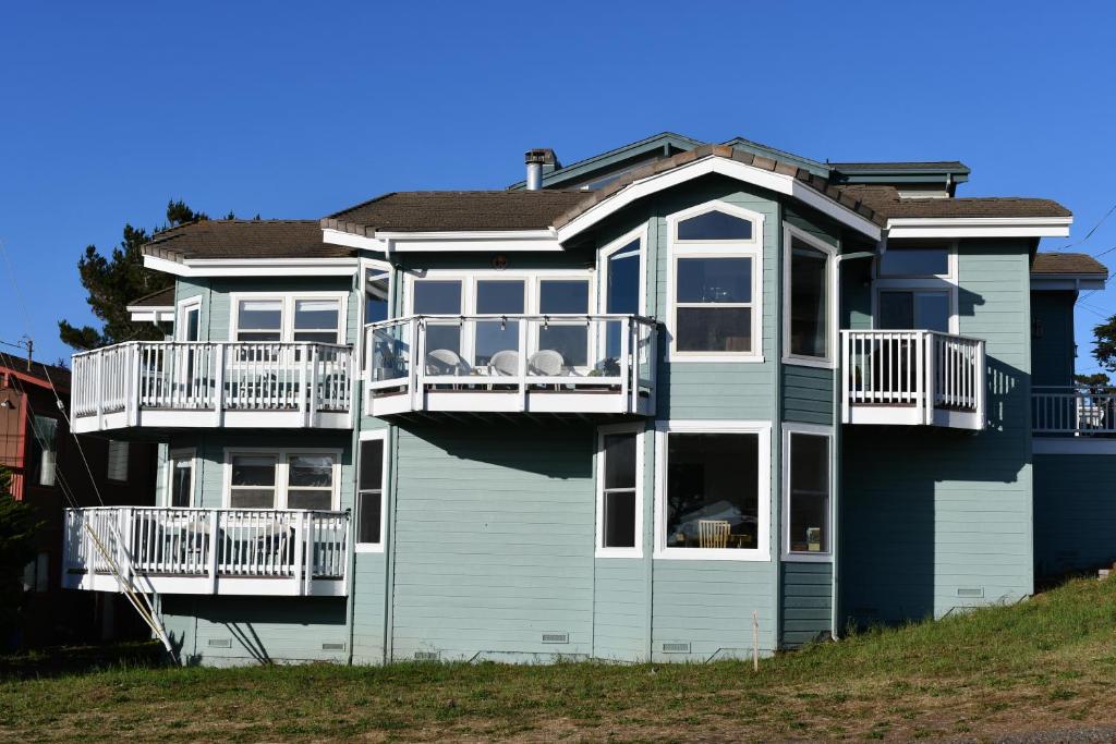 a large blue house with white balconies on it at For Sea Forever in Cambria