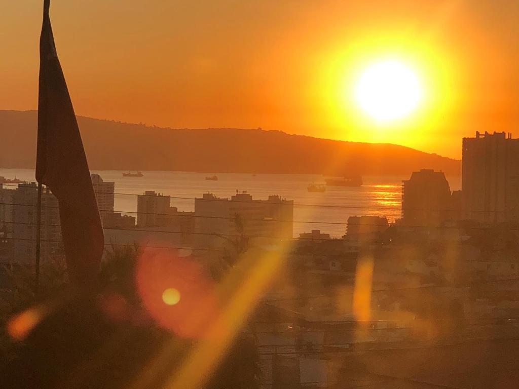 a view of the sun setting over a city at Carolina Hostal in Viña del Mar