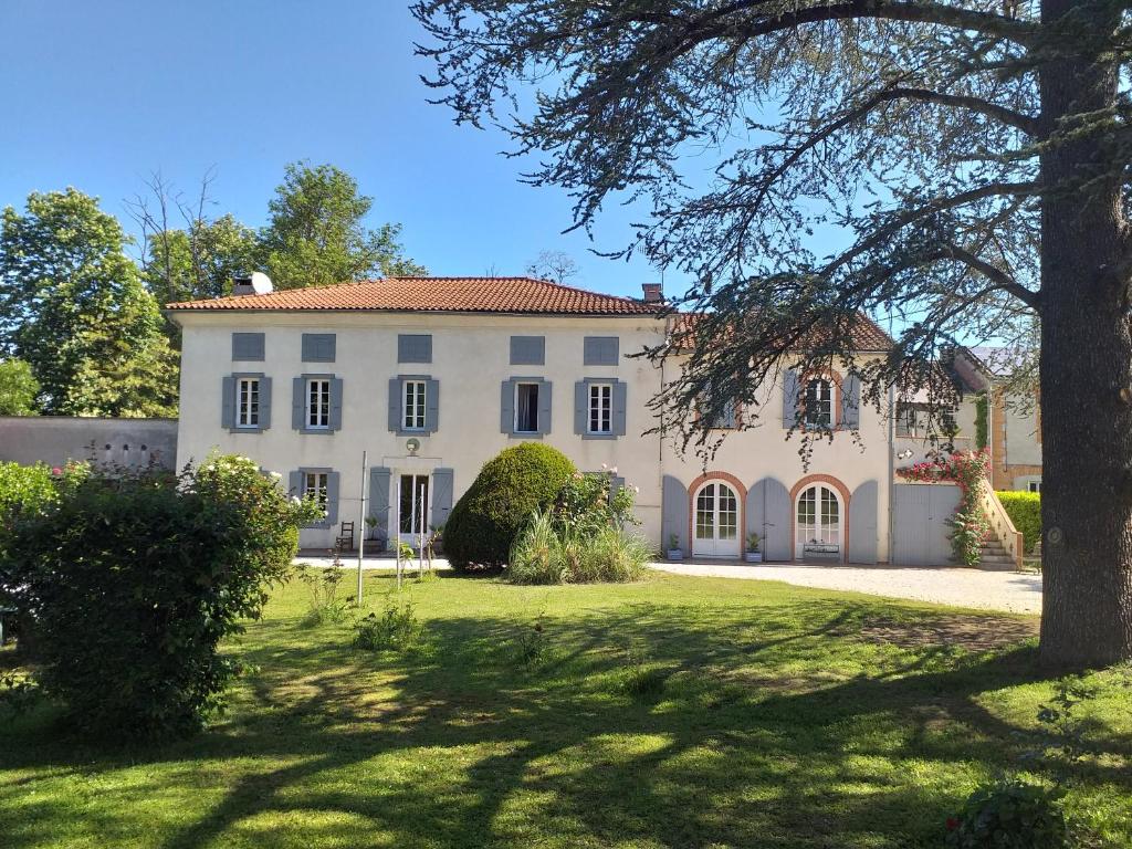 a large white house with a tree in the yard at Chez Celine et Philippe chambre Marie dans propriété de charme avec piscine in Le Fossat