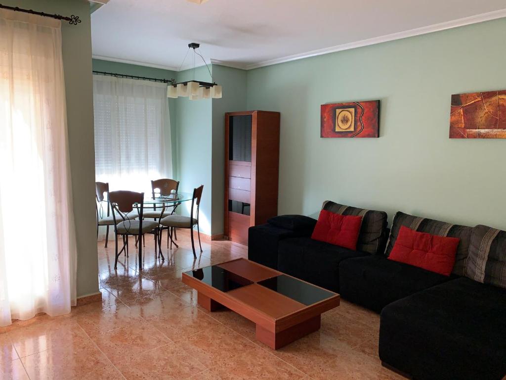 a living room with a black couch and a table at Apartamento Sanchiz in Monóvar