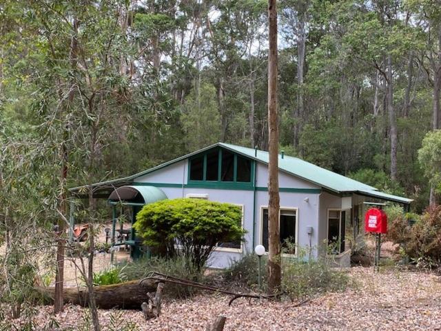 una pequeña casa en medio de un bosque en Harmony Forest Cottages & Lake side Lodge, en Margaret River Town