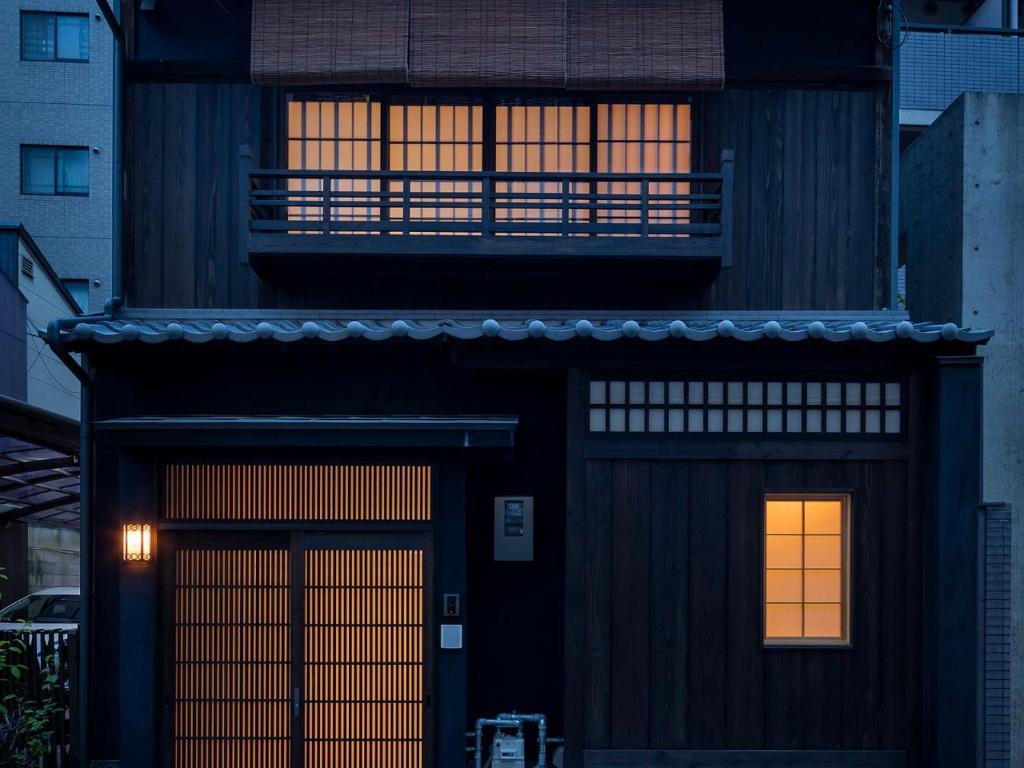 a black house with two doors and two windows at Natsume an Machiya House in Kyoto