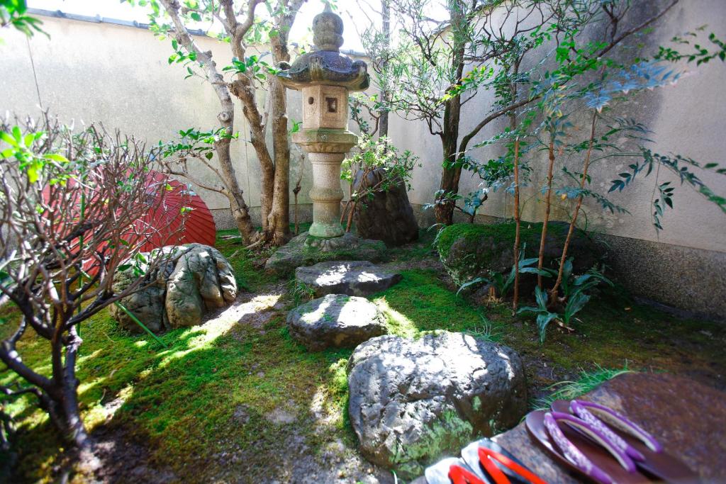 a garden with a bird house and rocks at Matsuharu ANN in Kyoto