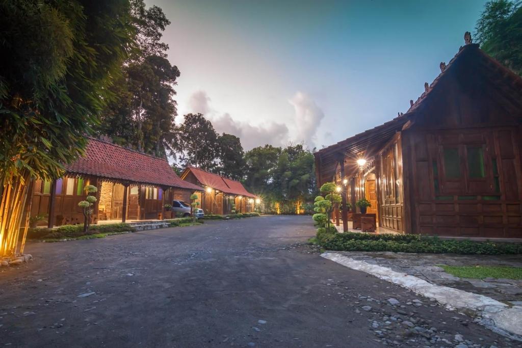 uma rua vazia em frente a alguns edifícios de madeira em The Omah Borobudur em Borobudur