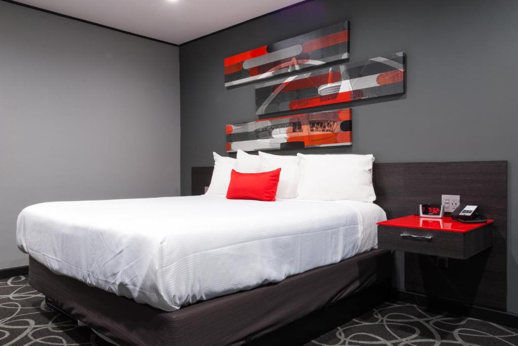 a bedroom with a large bed with red pillows at Astro Pasadena Hotel in Pasadena