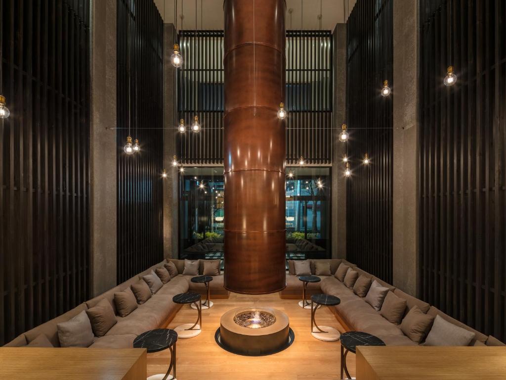 a large room with a large column and chairs at Twin-Line Hotel Karuizawa Japan in Karuizawa