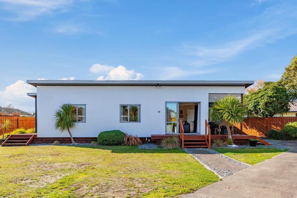 ein weißes Haus mit einer Veranda und einem Zaun in der Unterkunft Tranquil Tauhara - Taupo Central Holiday Home in Taupo