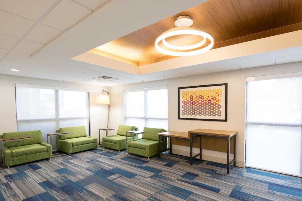 een wachtkamer met groene stoelen en een tafel bij Holiday Inn Express Atlanta-Stone Mountain, an IHG Hotel in Stone Mountain