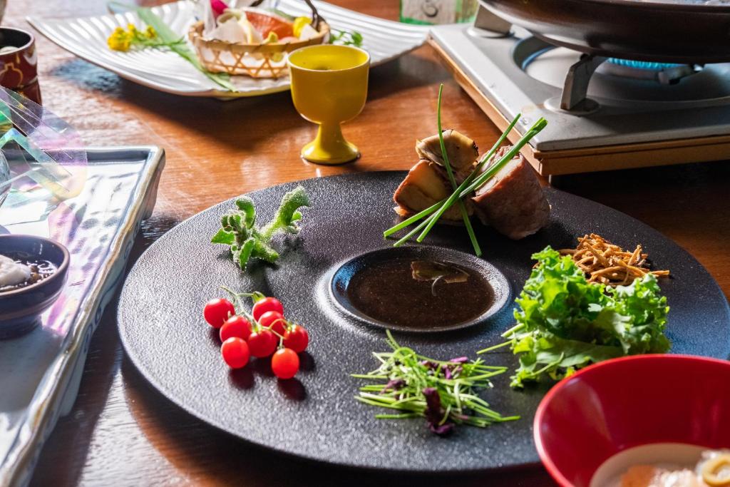 un plato de comida con verduras en una mesa en Hakuunsou, en Yugawara