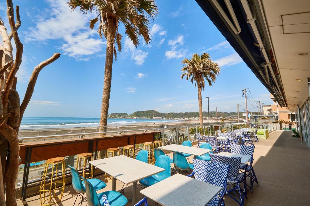 a patio with tables and chairs and the beach at zaimokuza seasons in Kamakura