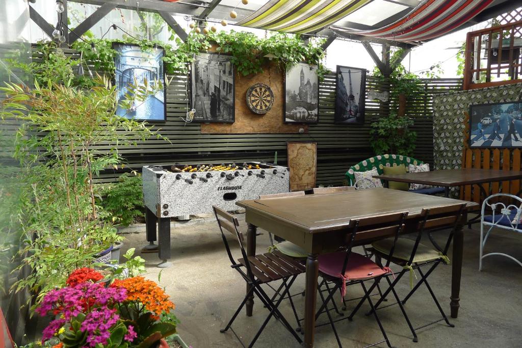 a patio with a table and chairs and flowers at The House Hostel in Sokcho