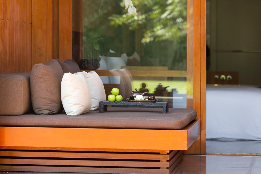 a bench with pillows and fruit on it at Anantara Chiang Mai Resort in Chiang Mai